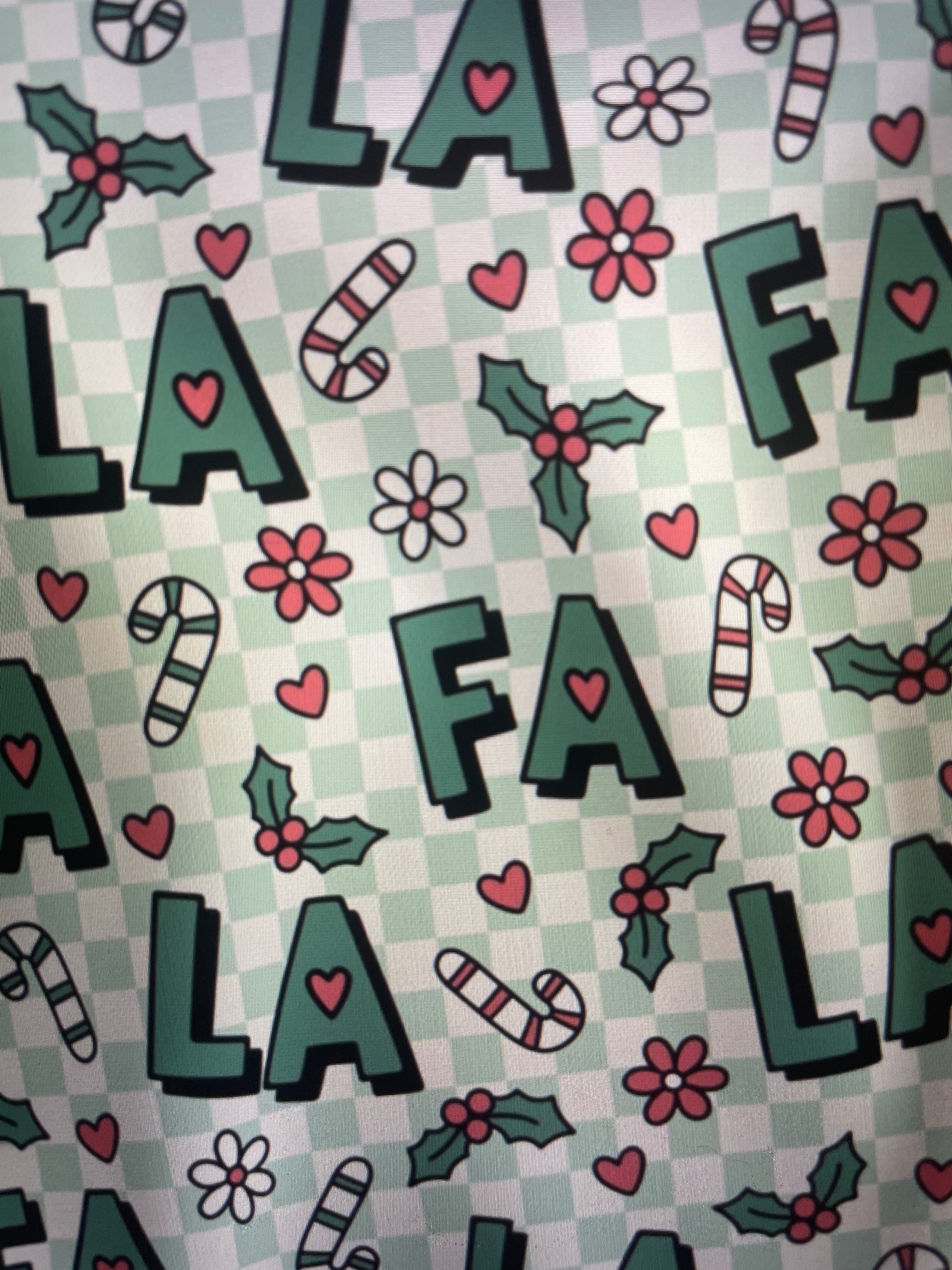 Patterned fabric with letters, flowers, and candy canes on a checkered background FA LA LA Holiday Apron Amanda Bright Designs Couture Collection