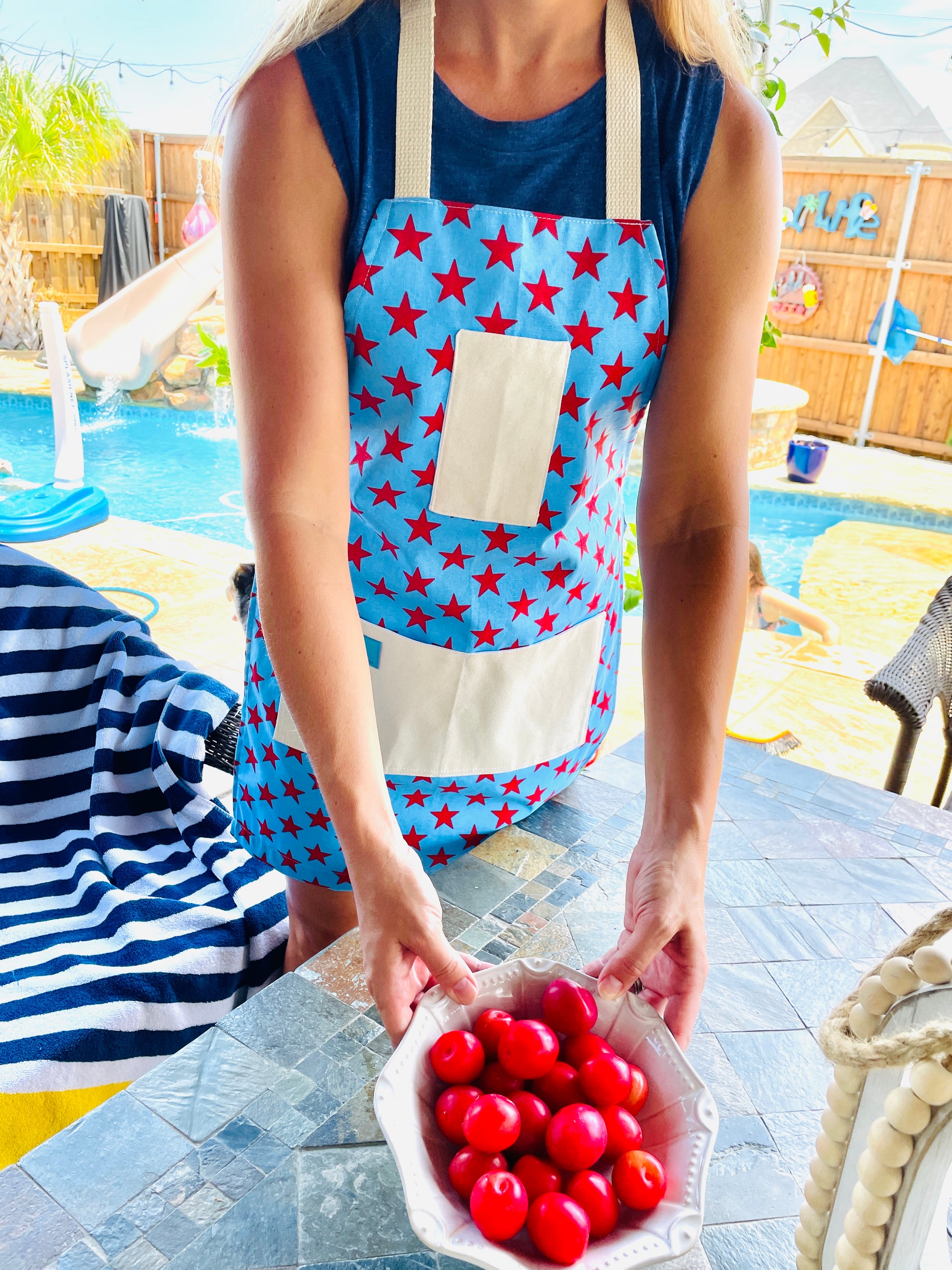 Two Medium Sized Ladies Betsy Ross kitchen apron fireworks stars and stripes American flag pattern fourth of july woman on her patio pool bbq grill backyard