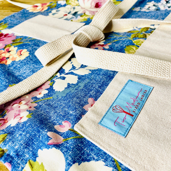 Two Medium Sized Ladies Betty Crocker Apron blue floral spring flowers mauve peach oversized blooms cotton closeup view