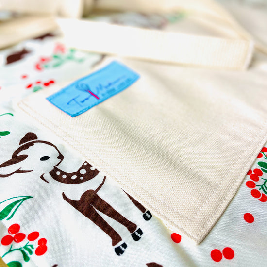 Two Medium Sized Ladies Baby Deer Reindeer Forest Fawn Apron featuring brown spotted fawns green holly red berries and mushrooms on forest floor