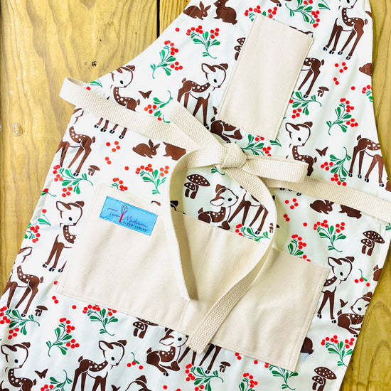 Two Medium Sized Ladies Reindeer Forest Fawn Apron featuring brown spotted fawns green holly red berries mushrooms butterflies