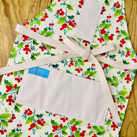 Two Medium Sized Ladies winter apron holly berry with bright red berries and holly tree leaves outdoor beauty Merry Christmas cardinals