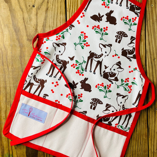 Two Medium Sized Ladies Forest Fawn Children's Christmas Apron with Reindeer Mushrooms Rabbits and Red Trim and Red Apron Strings