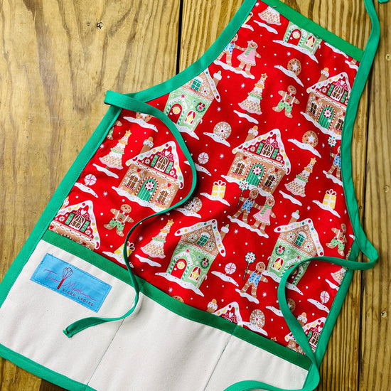 Two Medium Sized Ladies Children's Gingerbread House Gingerbread House Man Cookie Apron Red with Pink Details and Green Apron Strings