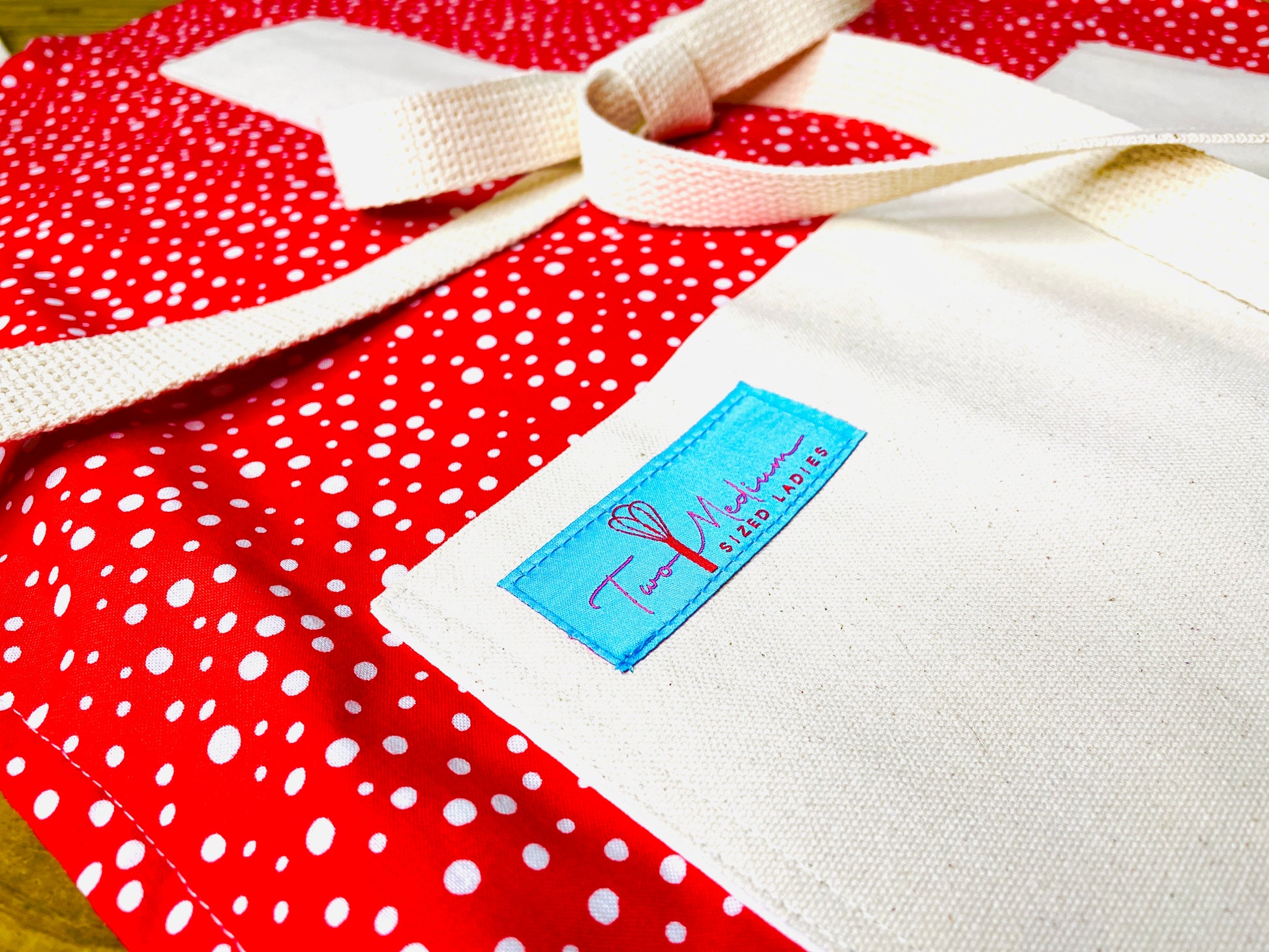 Two Medium Sized Ladies vintage snowfall Charlie Brown special style snowflakes on a bright red apron background