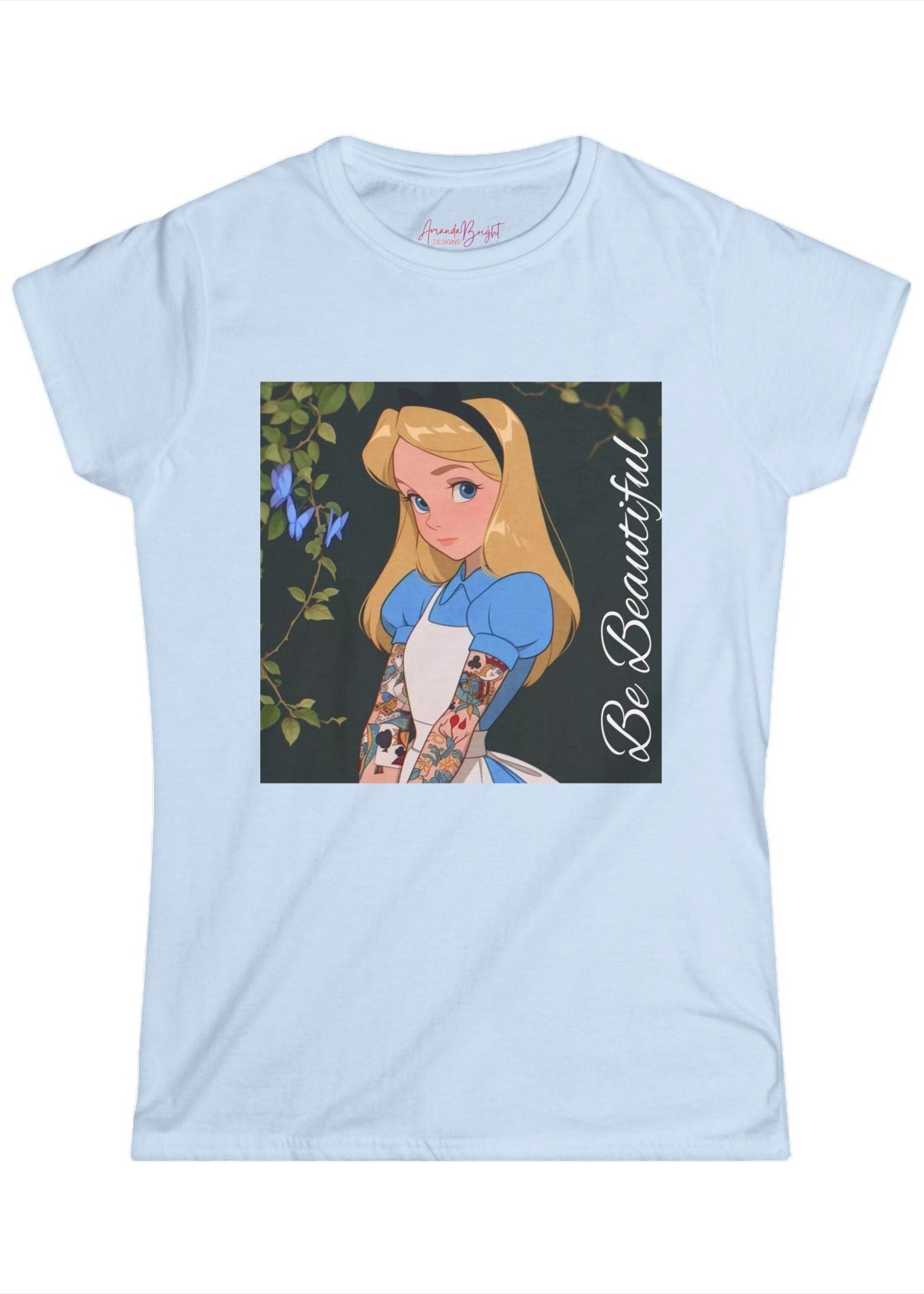 Amanda Bright Designs graphic tshirt Be Beautiful series Alice in Wonderland tattooed sleeve light blue short-sleeve t-shirt with a graphic print of Alice from Alice in Wonderland, featuring her blonde hair, blue dress, and the text 'Be Beautiful' written vertically on the right side of the graphic.