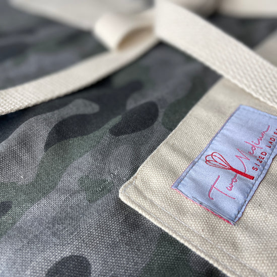 Amanda Bright Designs camouflage apron featuring gray and green color scheme, with canvas pockets and an adjustable straps