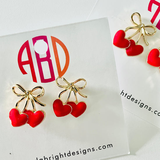 Amanda Bright Designs pair of gold bow and red heart stud earrings