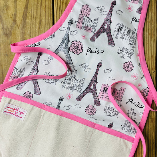 Children's apron with Eiffel Tower design on a wooden surface
