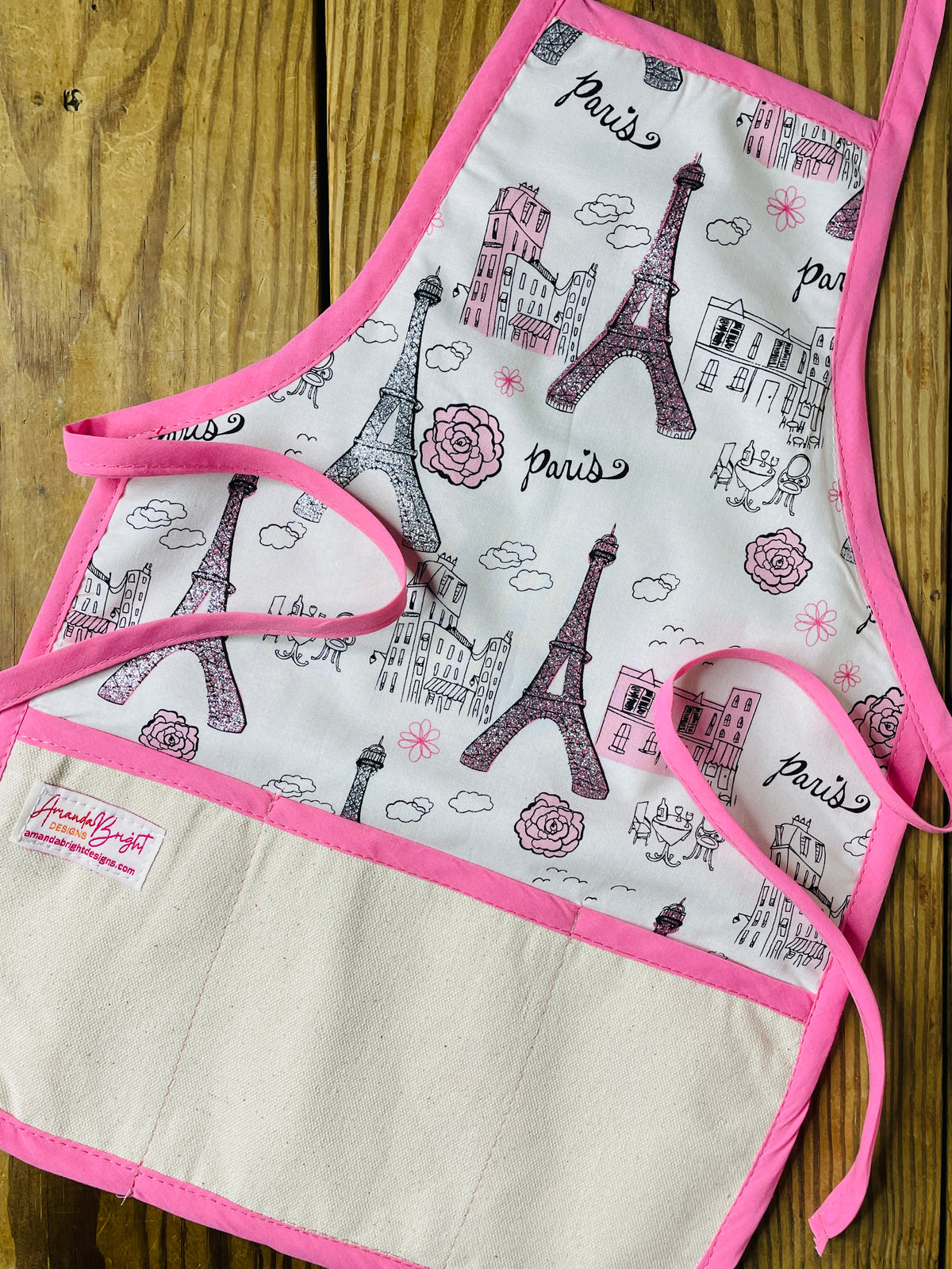 Children's apron with Eiffel Tower design on a wooden surface