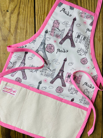 Children's apron with Eiffel Tower design on a wooden surface