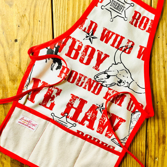 Amanda Bright Designs Jane Apron Children's Cowboy Print Giddy Wild West Horse Spurs Boots with Red Apron Strings and Three Pockets