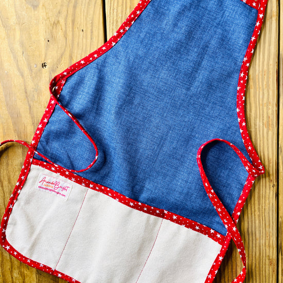 Amanda Bright Designs handmade dark wash denim apron with canvas pockets and deep red stars trim
