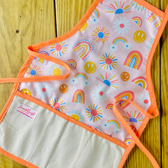 Amanda Bright Designs Children's apron with colorful rainbows, smiley faces, sunshine with peach strings 