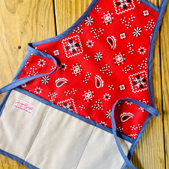 Amanda Bright Designs Red bandana-patterned children’s apron with denim blue trim and strings