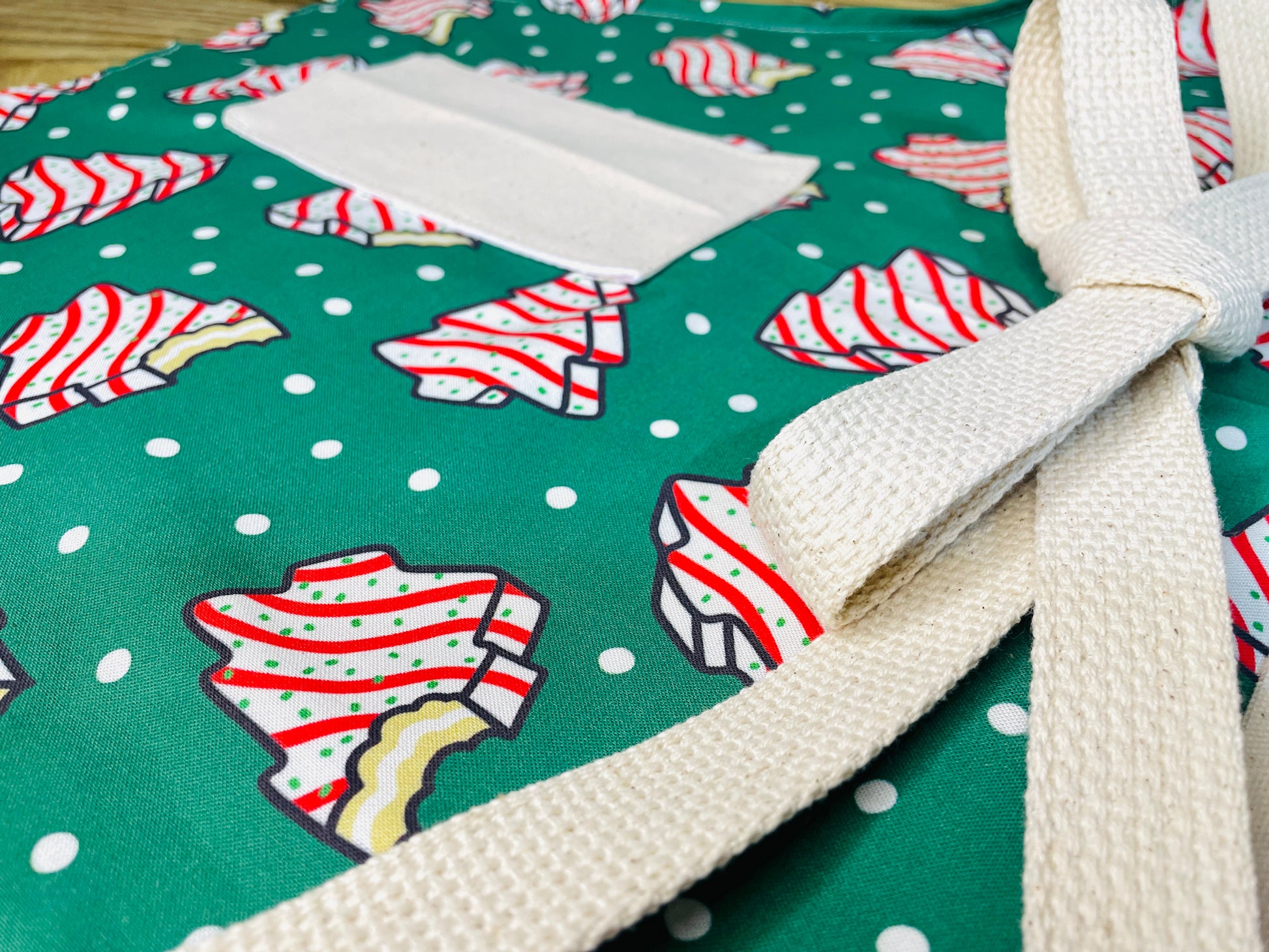 Amanda Bright Designs Couture Apron Little Debbie white with red icing Christmas Tree Cake Apron on green polkadot fabric for the holidays