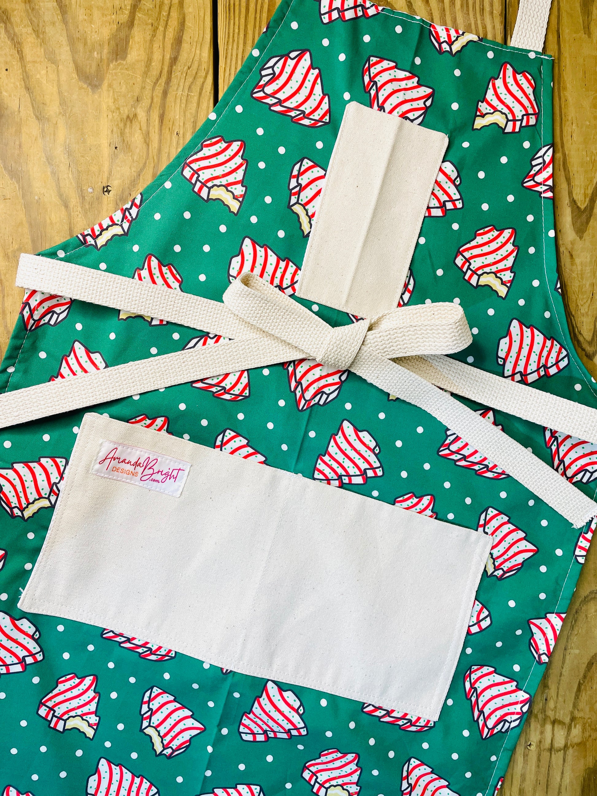Amanda Bright Designs Couture Apron Little Debbie white with red icing Christmas Tree Cake Apron on green polkadot fabric for the holidays