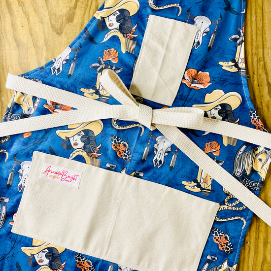 Blue apron with cowgirl pattern Amanda bright designs rattlesnake horse head, Rose cowboy boots western