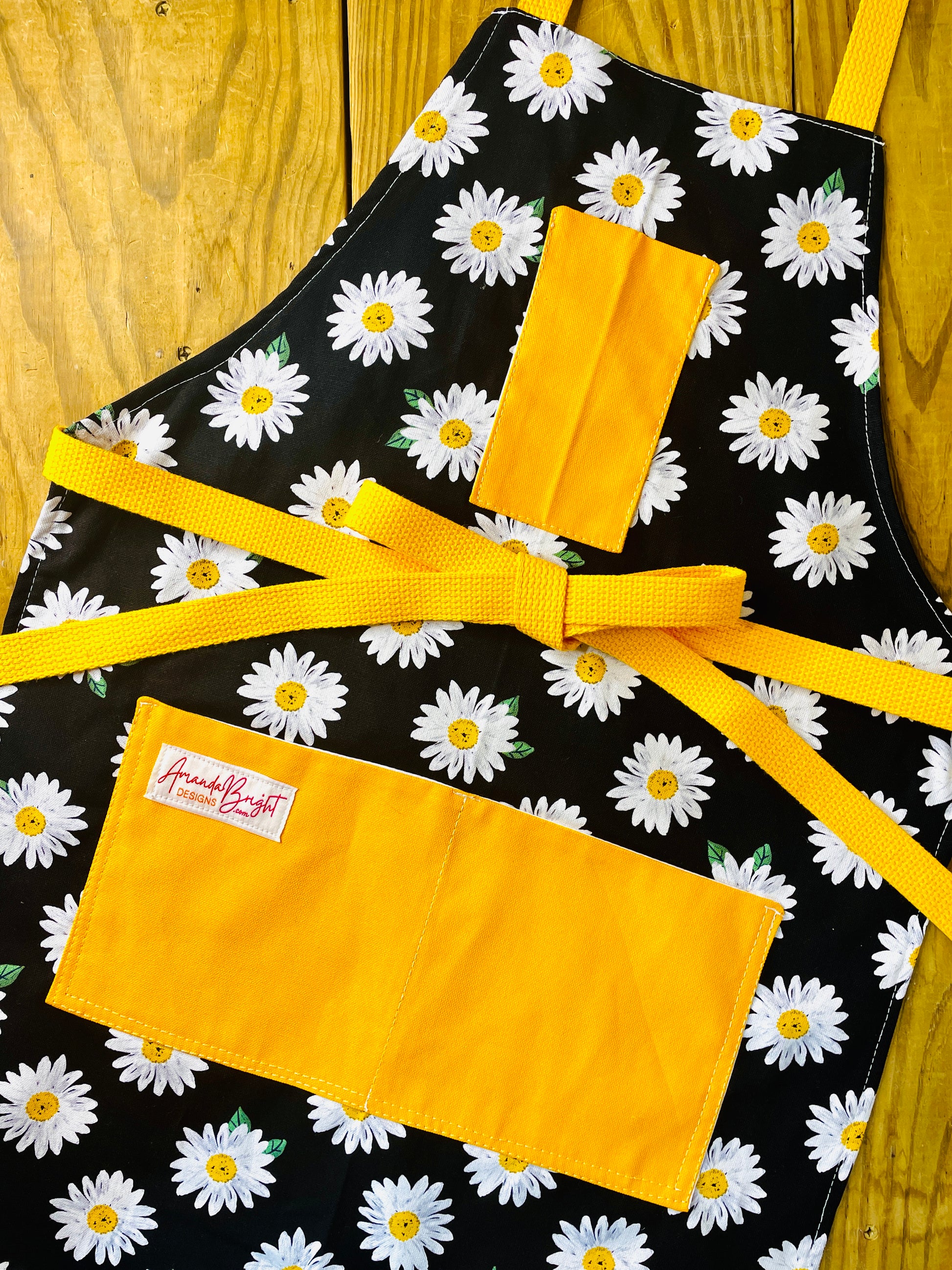 Amanda Bright Designs black apron with white daisy pattern apron with gold strings and pockets