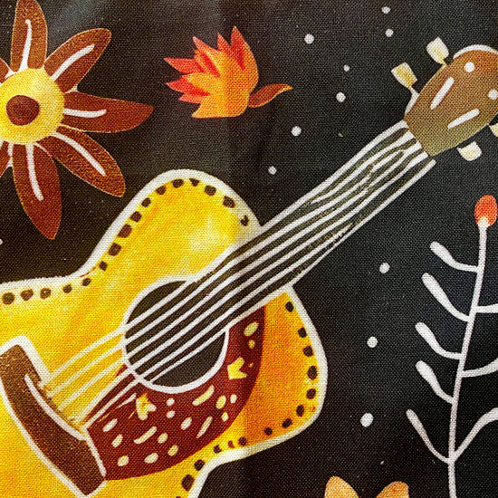 Amanda Bright Designs Desert cowgirl Apron with colorful western guitar cactus cowboy hat sunflower pattern on black background