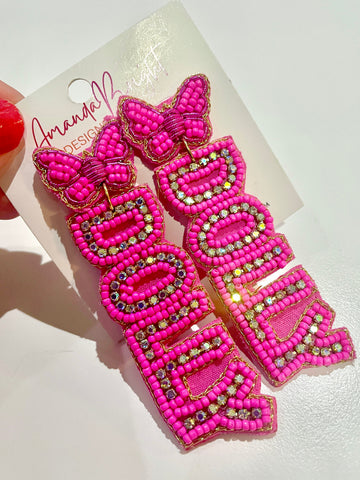 Amanda Bright Designs pair of bright pink beaded letter earrings spelling 'DOLLY' with butterfly tops and rhinestones.