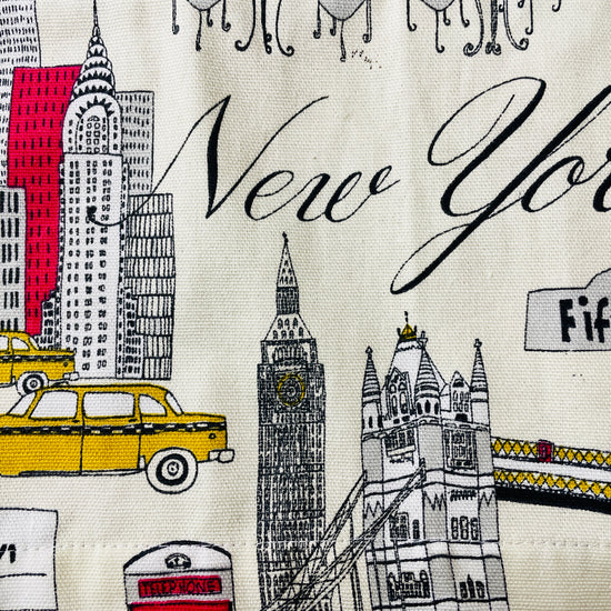 Amanda Bright Designs Evelyn Apron Illustrated fabric with New York-themed design featuring a taxi, Big Ben, and Fifth Avenue.