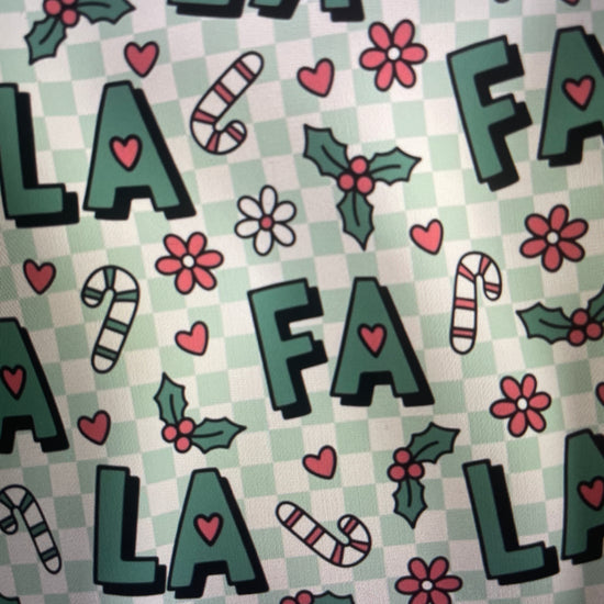 Patterned fabric with letters, flowers, and candy canes on a checkered background FA LA LA Holiday Apron Amanda Bright Designs Couture Collection