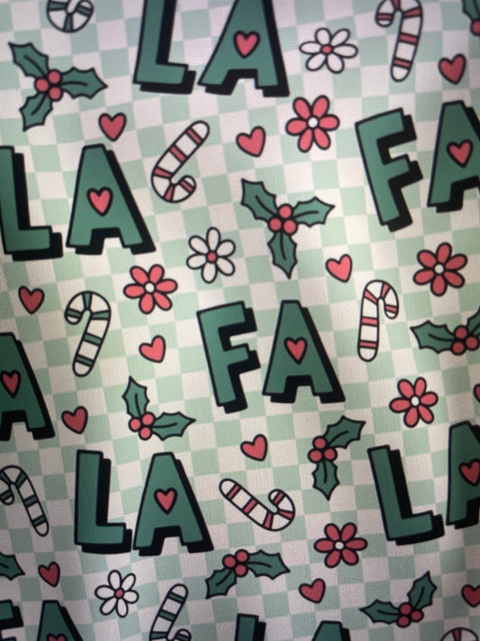 Patterned fabric with letters, flowers, and candy canes on a checkered background FA LA LA Holiday Apron Amanda Bright Designs Couture Collection