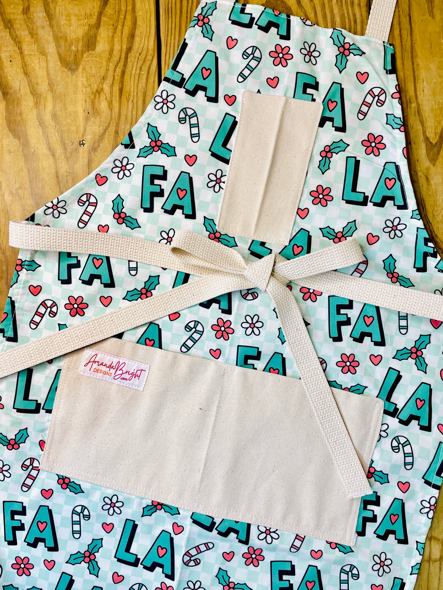 Amanda Bright Designs Fa La La Christmas Apron in green checkered with candy canes and flowers