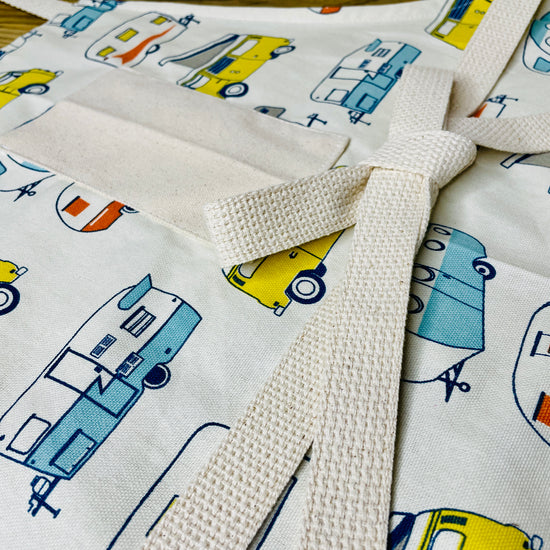Amanda Bright Designs apron with camper and van pattern on a wooden surface