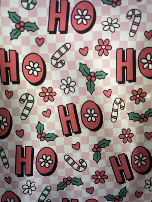 Patterned fabric with 'HO HO HO' text, candy canes, flowers, and holly leaves on a checkered background Amanda Bright Designs Couture Apron