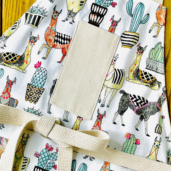 Amanda bright designs multicolor llama apron cutaway showing llamas with decorative saddles southwest cactus flowers in herringbone and harlequin pattern pots