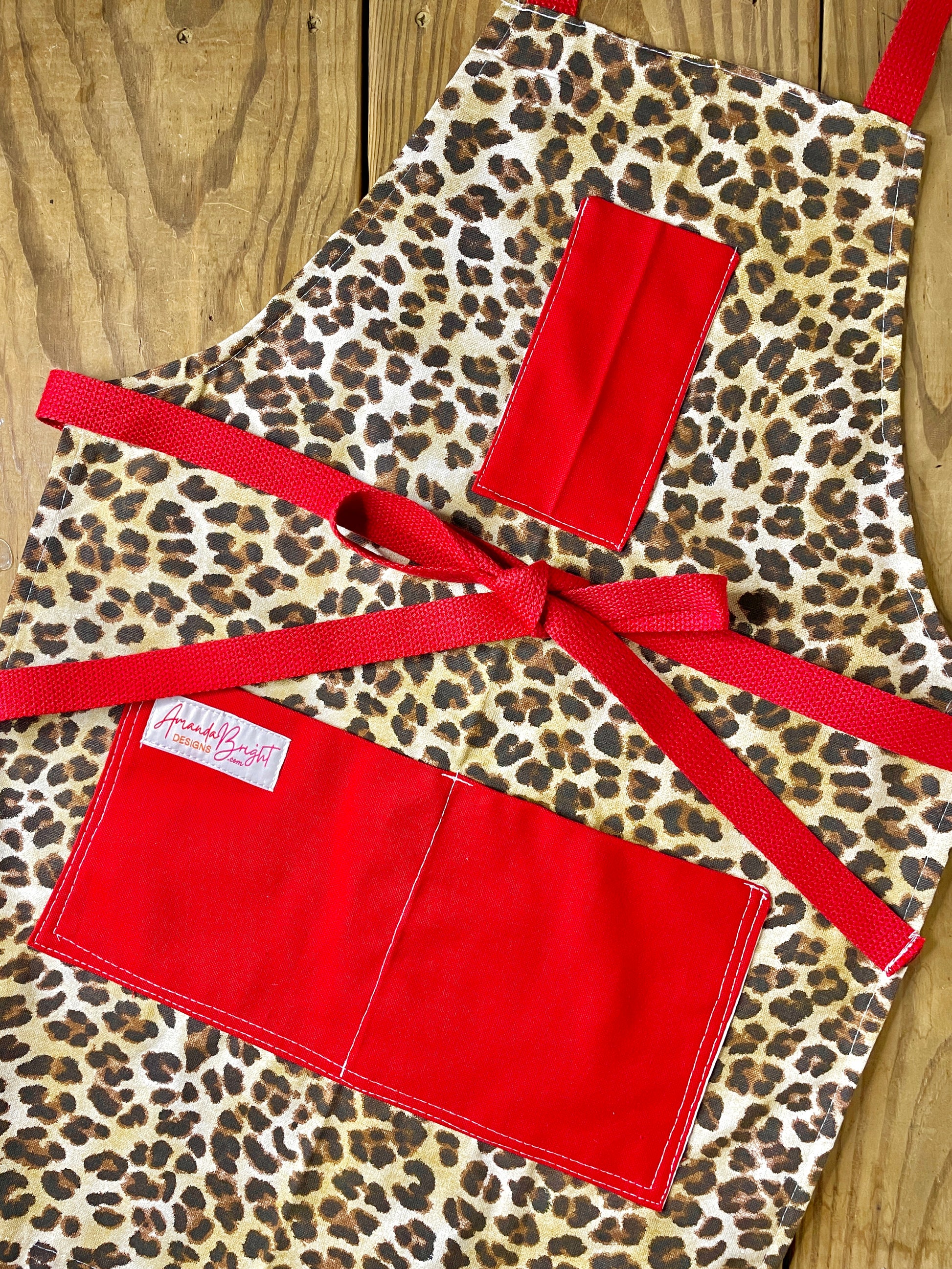 Amanda Bright Designs Leopard print apron with red accents 