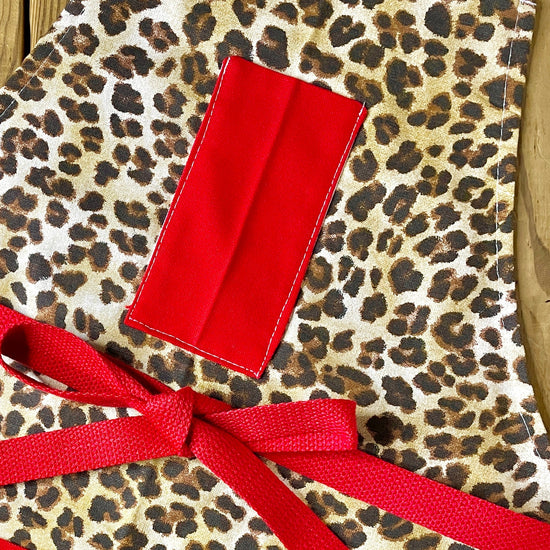 Amanda Bright Designs Leopard print apron cutaway with red pockets red strings and high fashion design