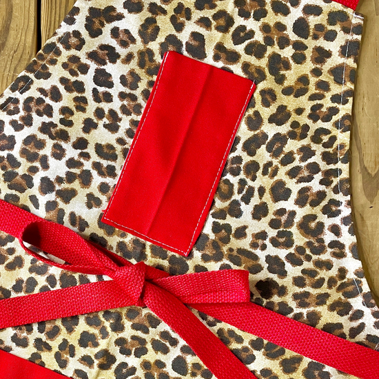 Leopard print apron with red pockets and red strings by amanda bright designs