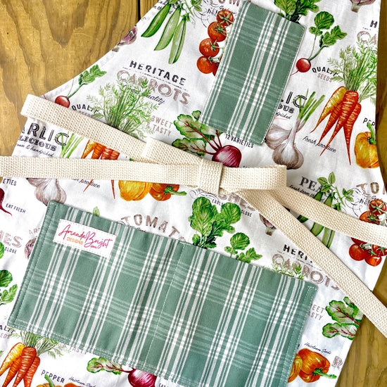 Amanda Bright Designs Farmhouse kitchen apron with vegetable-themed designs and green plaid pockets