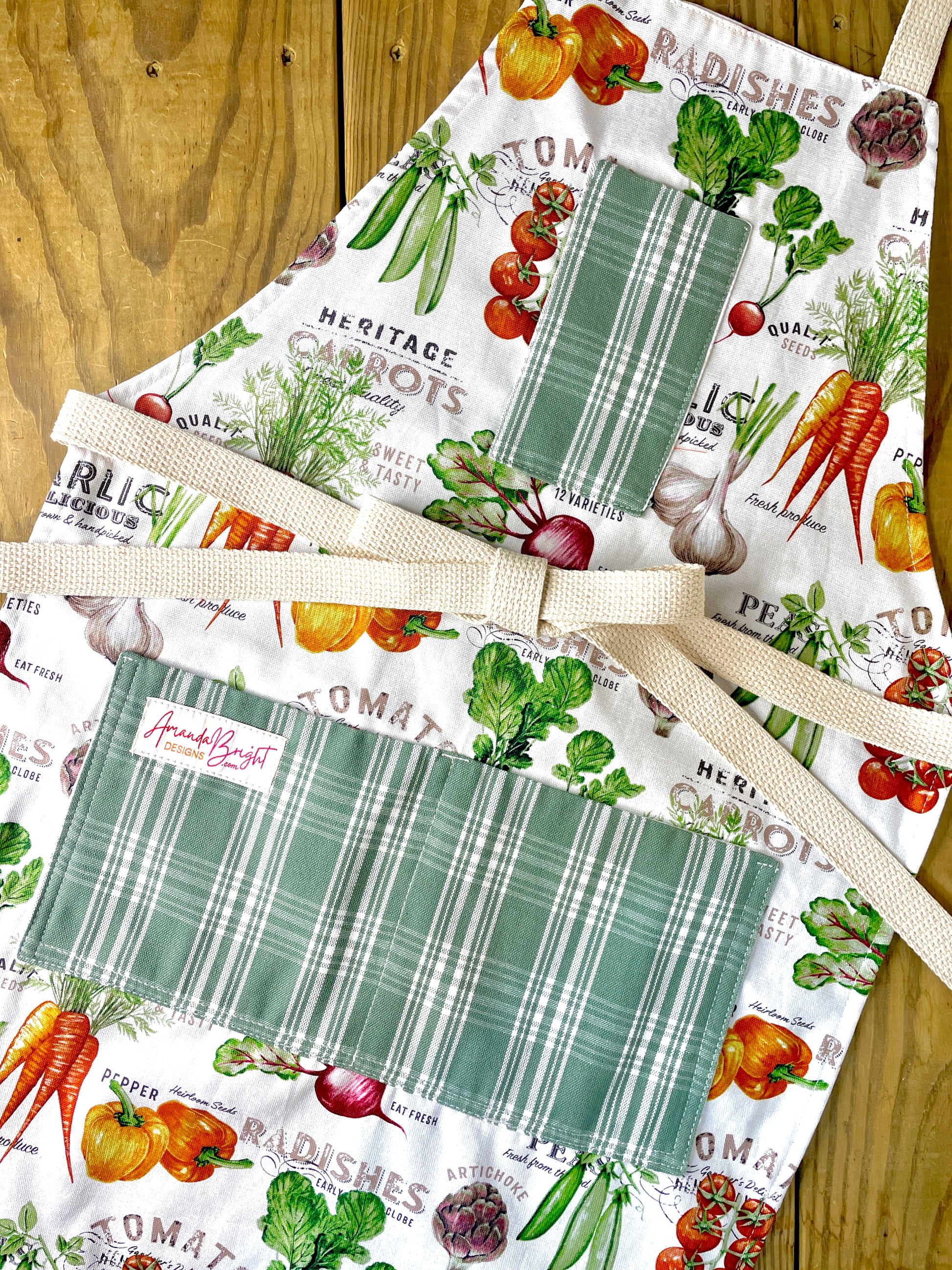 Amanda Bright Designs Farmhouse kitchen apron with vegetable-themed designs and green plaid pockets