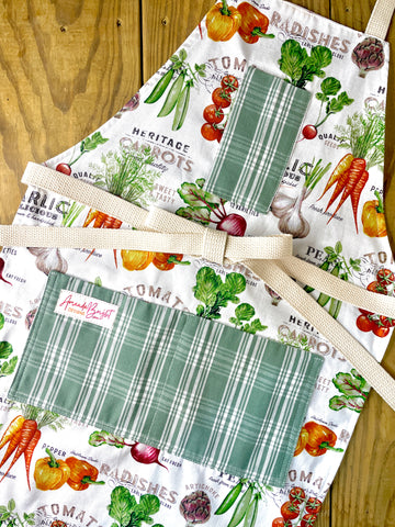 Amanda Bright Designs Farmhouse kitchen apron with vegetable-themed designs and green plaid pockets