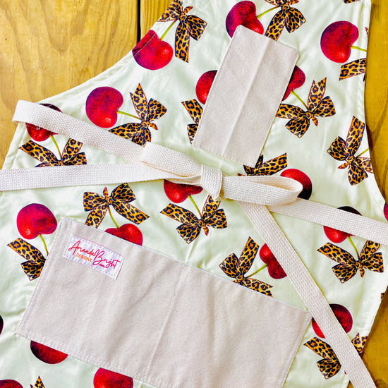 Amanda Bright Designs leopard bows bright red cherries rockabilly style vintage couture apron with designer print pin up aesthetic
