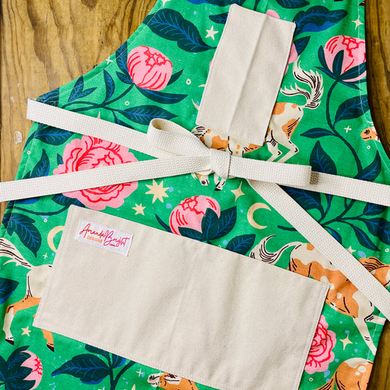 Amanda Bright Designs Moonlit meadows apron with horse and pink peony floral pattern with moon and stars on green background