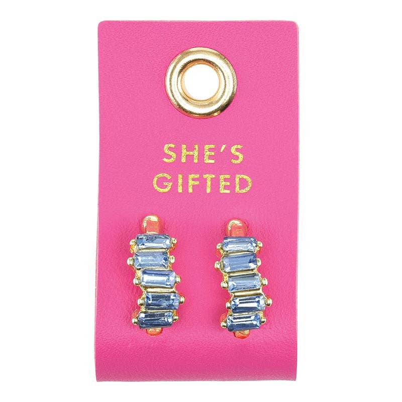 Blue gradient crystal earring studs set in gold on a hot pink leather tab that says "She's Gifted"