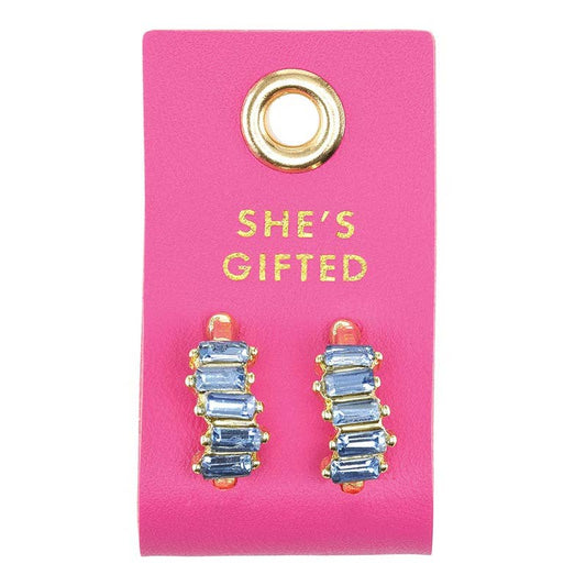 Blue gradient crystal earring studs set in gold on a hot pink leather tab that says "She's Gifted"
