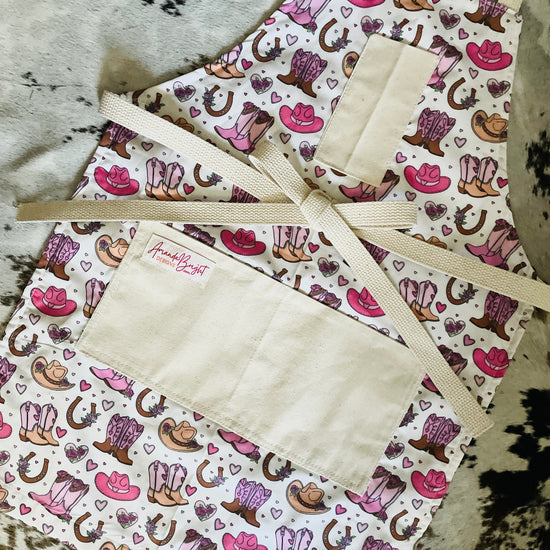 Cowboy pattern apron with pink cowboy boots pink cowboy hat horseshoes hearts Amanda Bright Designs couture collection