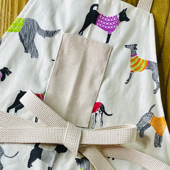 Amanda Bright Designs Pixie sweater wearing dog apron 
