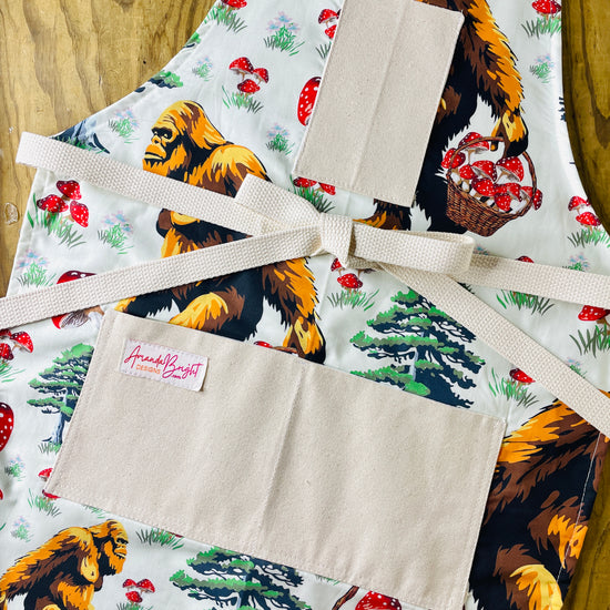 Apron with bigfoot carrying basket of mushrooms Amanda bright designs 