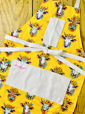 Amanda Bright Designs hand drawn cows heads with sunflowers and daisies on golden yellow polkadot background couture designer apron
