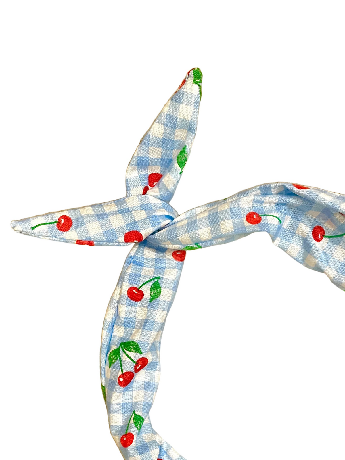 A light blue and white gingham headband with a red cherry and green leaf pattern