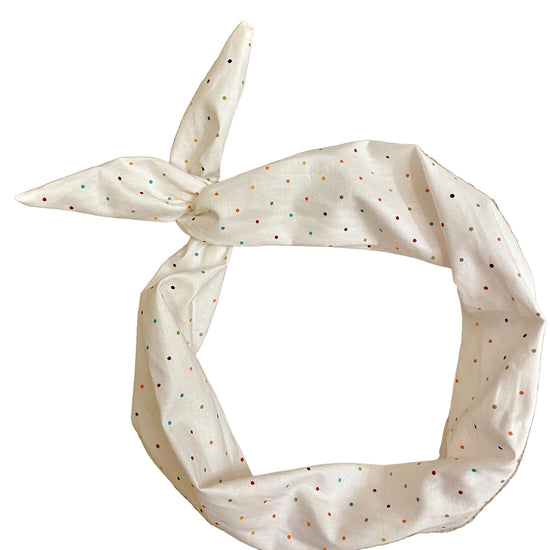 Amanda Bright Designs ivory fabric headband with small multicolored polka dots, tied in a knot