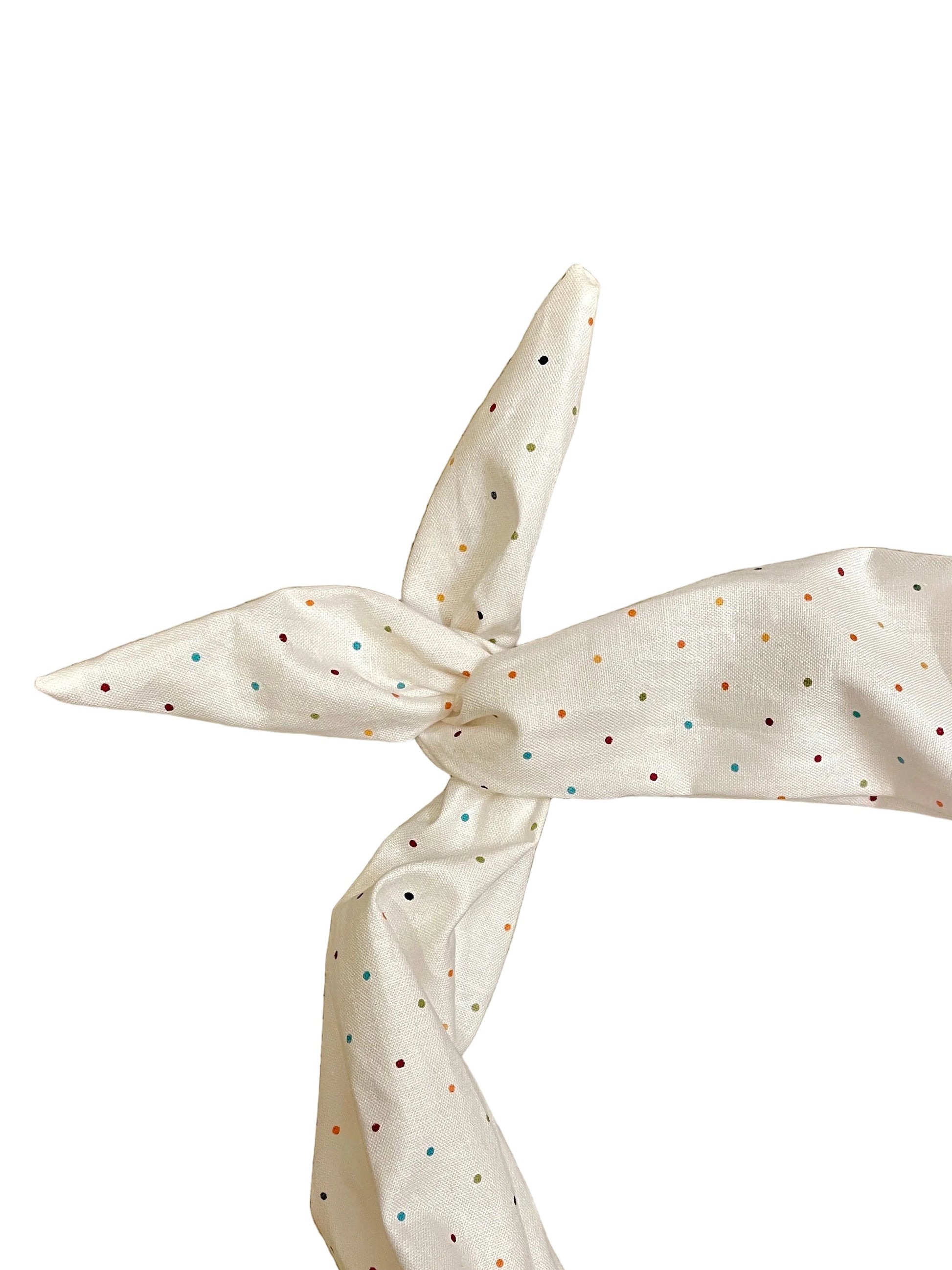 Amanda Bright Designs ivory fabric headband with small multicolored polka dots, tied in a knot 