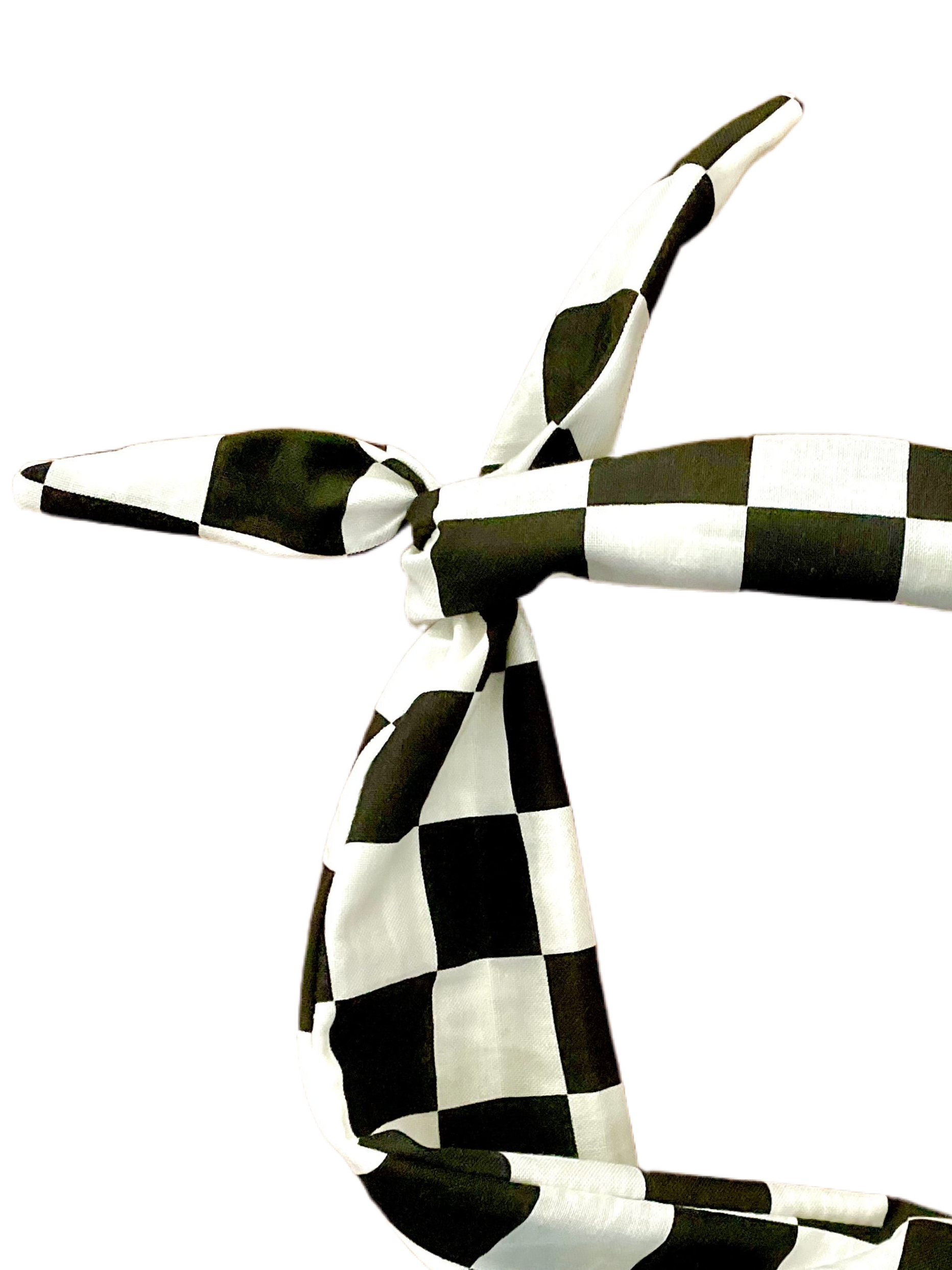 A black and white checkered headband tied in a knot amanda bright designs moldable bendable original tie headband